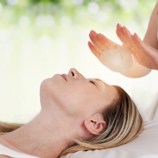 Woman having reiki healing treatment , alternative medicine concept.